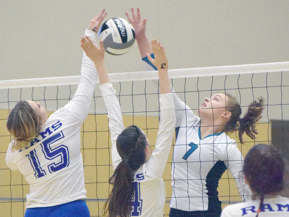 Photo by Joey Klecka/Peninsula Clarion Nikiski middle Bethany Carstens (7) blocks a shot from Monroe Catholic's Maija Hajdukovich (15) and Madlyn Leslie on Thursday morning at the Class 3A state volleyball tournament at the Alaska Airlines Arena in Anchorage.