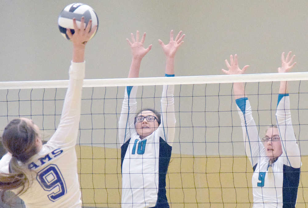 Photo by Joey Klecka/Peninsula Clarion Nikiski middle hitters Ayla Pitt (10) and Jamie Yerkes work together to block a shot from Monroe Catholic opposite hitter Jordyn Sager, Thursday morning at the Class 3A state volleyball tournament at the Alaska Airlines Arena in Anchorage.