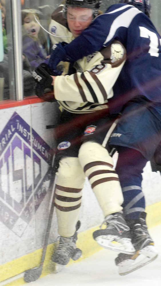 Photo by Jeff Helminiak/Peninsula Clarion Kenai River's Alex Dingeldein gets taken into the boards by Jack Gates of the Janesville (Wisconsin) Jets on Friday at the Soldotna Regional Sports Complex.