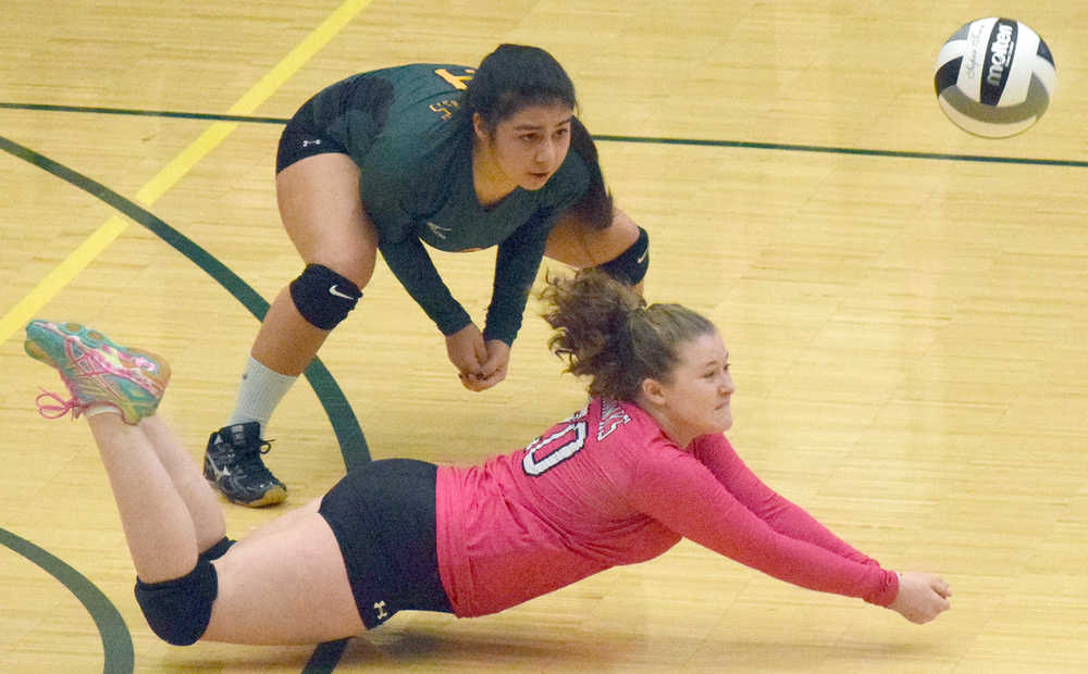Photo by Joey Klecka/Peninsula Clarion Seward libero Kimmie Hubbard (in pink) digs for a ball with teammate Tia Miranda, Friday against Monroe Catholic in the Class 3A state volleyball tournament held at the Alaska Airlines Arena in Anchorage.
