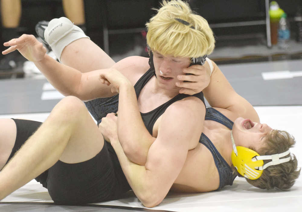 Photo by Jeff Helminiak/Peninsula Clarion Homer's Kyle Wells reacts after hyperextending his wrist while wrestling Colony's Chayse Eby on Saturday in the championship dual at the Peninsula Duals at Nikiski High School. Wells fought through the injury to score a 7-6 victory.