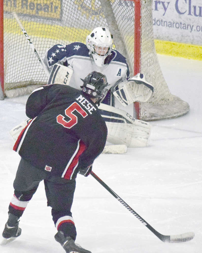 Photo by Joey Klecka/Peninsula Clarion Kenai Central's Levi Mese (5) slaps a shot towards Soldotna goaltender Billy Yoder Tuesday night at the Soldotna Regional Sports Complex.