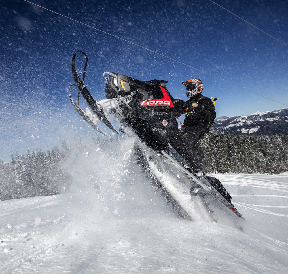 In this Tuesday, March 17, 2016 photo, snowmobiler Kurt Zeutschel, of Issaquah, catches some air as he rises up and over a berm off a trail near Crystal Springs Sno-Park, just east of Snoqualmie Pass, Wash. (Steve Ringman/The Seattle Times via AP)