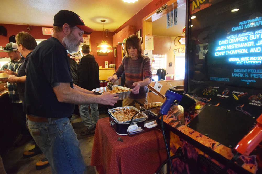 Photo by Megan Pacer/Peninsula Clarion Charlie's Pizza owner Steve Chamberlain and Maryann Yerkes, an employee, keep the food stocked during the annual Thanksgiving meal put on at the restaurant Thursday, Nov. 24, 2016 in Nikiski, Alaska. Set to close at the end of the year, the owners of Charlie's Pizza hope to continue providing Thanksgiving meals in the future on a smaller scale.