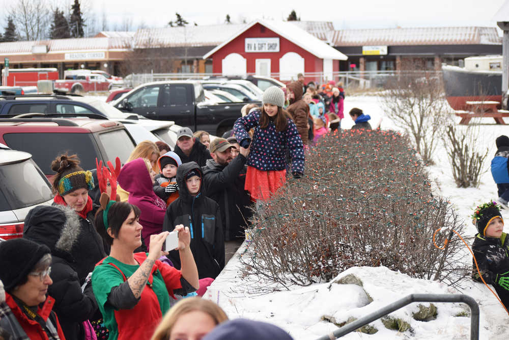 Photo by Megan Pacer/Peninsula Clarion Parents and children eagerly await Santa's arrival in a line that snakes to the end of the Kenai Chamber of Commerce and Visitor Center parking lot Friday, Nov. 25, 2016 in Kenai, Alaska. Santa has arrived at the center for the last three decades to take note of what local children want for Christmas.