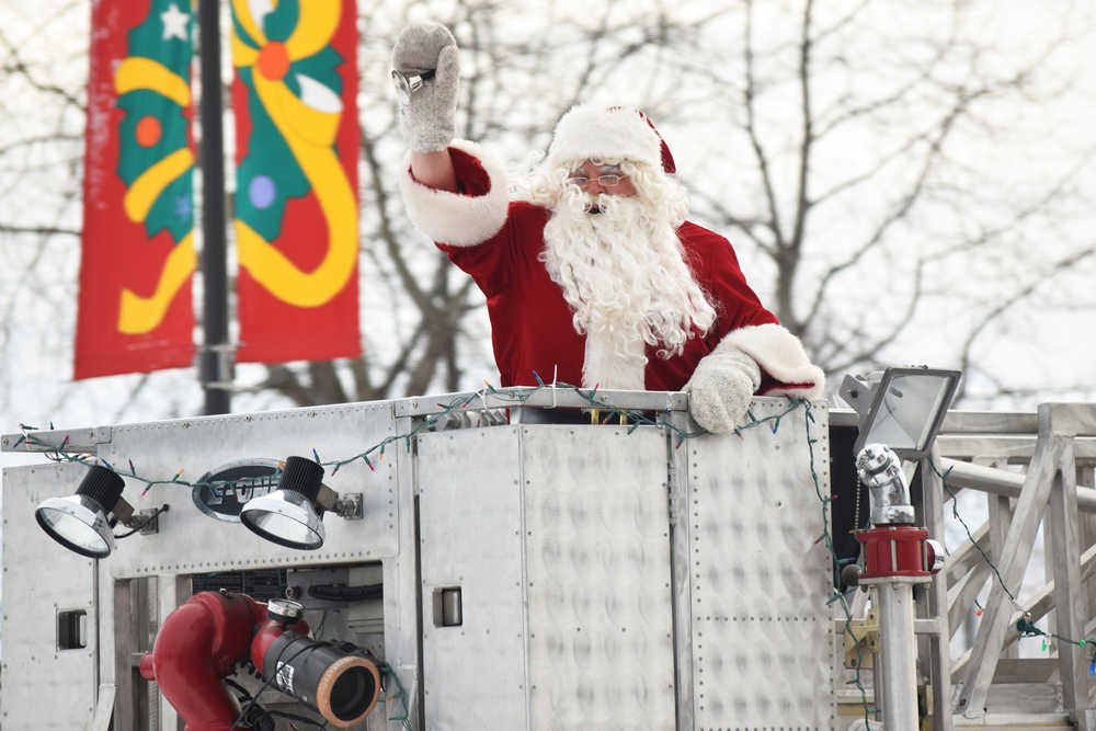 Photo by Megan Pacer/Peninsula Clarion Santa greets a crowd of excited families as he cruises into the Kenai Chamber of Commerce and Visitor Center parking lot on a Kenai Fire Deoartment engine Friday, Nov. 25, 2016 in Kenai, Alaska.