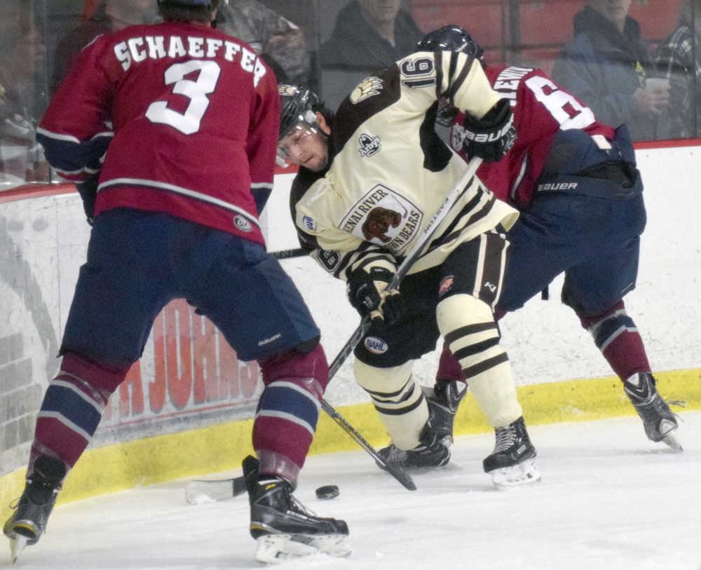 Photo by Jeff Helminiak/Peninsula Clarion Brown Bears forward David Kaplan battles in the corner with Nolan Schaeffer and Dean Hewines of Fairbanks on Friday at the Soldotna Regional Sports Complex.