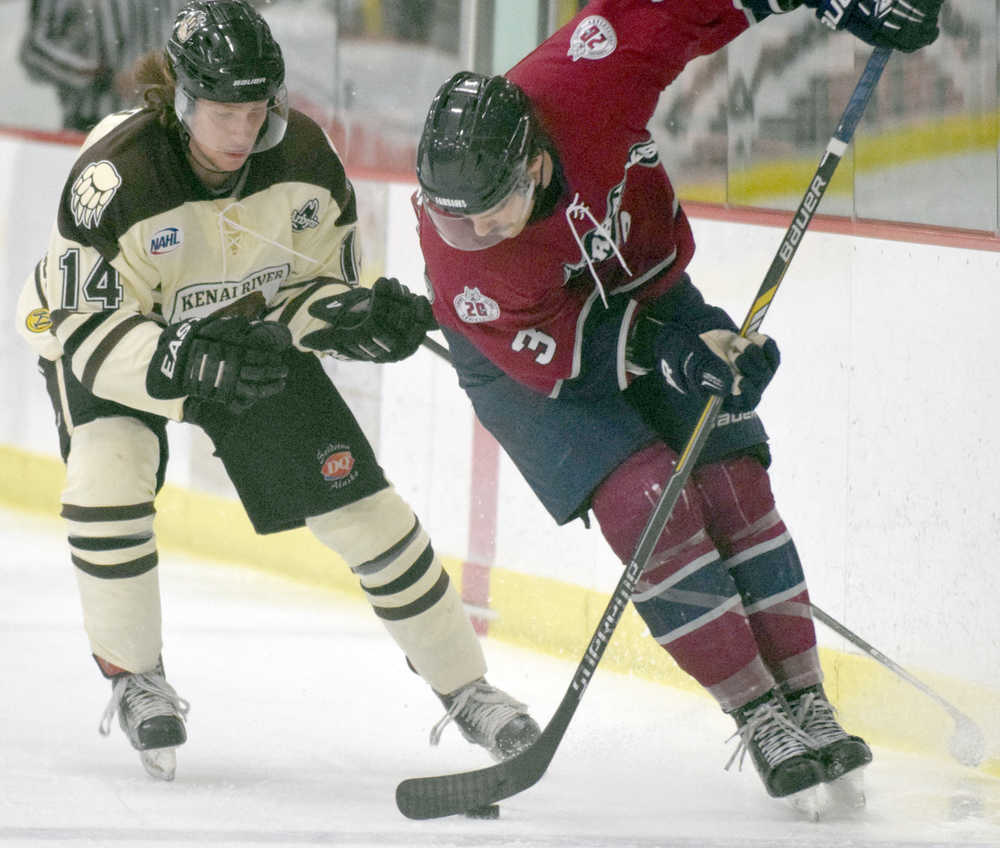 Photo by Jeff Helminiak/Peninsula Clarion Anthony Tzveyn of the Brown Bears and Nolan Schaeffer of the Ice Dogs tangle for the puck Friday at the Soldotna Regional Sports Complex.