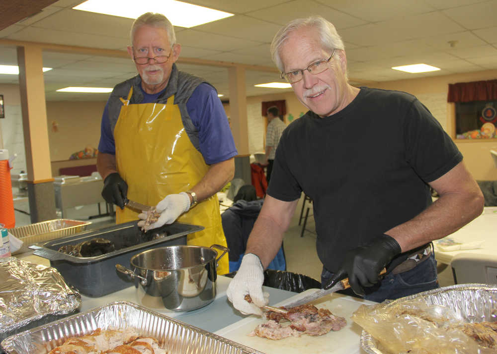 Mark Hutton and Dave Peterson carve numerous turkeys for the Salvation Army community dinner.