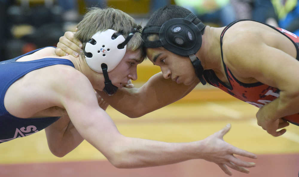 Photo by Jeff Helminiak/Peninsula Clarion Soldotna's Bechler Metcalf and Kenai Central's Keyshawn McEnerney tie up at 152 pounds at Kenai Central High School on Thursday. Metcalf scored a 10-4 victory.
