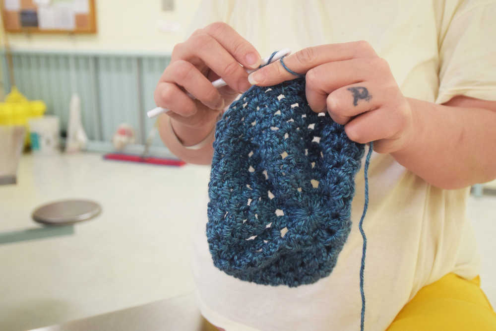 Photo by Megan Pacer/Peninsula Clarion A woman crochets a teal hat during a session of the Wildwood Correctional Complex's inmate crochet program Tuesday, Nov. 29, 2016 at the complex's pretrial building in Kenai, Alaska.