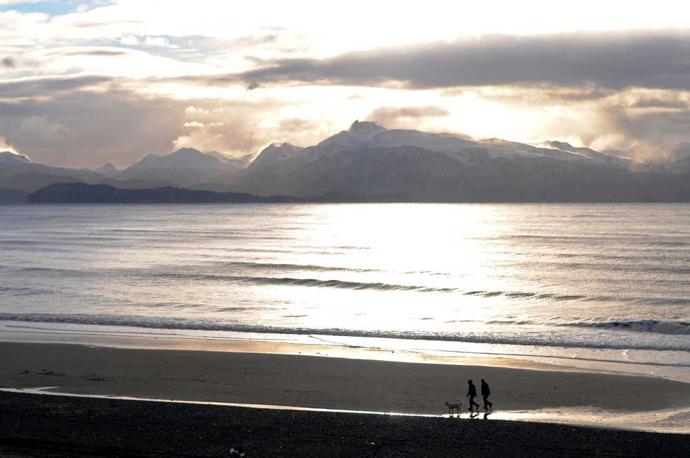 Photo by Elizabeth Earl/Peninsula Clarion Two people walk their dog across Bishop's Beach on Saturday, Dec. 3, 2016 in Homer, Alaska. Homer got several inches of snow between Wednesday and Saturday, and while the clouds broke Saturday to provide a little sunshine, the wind was preparing to roll in across Kachemak Bay. The National Oceanic and Atmospheric Administration predicts the wind will keep blowing in the area for the remainder of the week, with winds about 20 knots on Monday, according to the NOAA marine forecast.