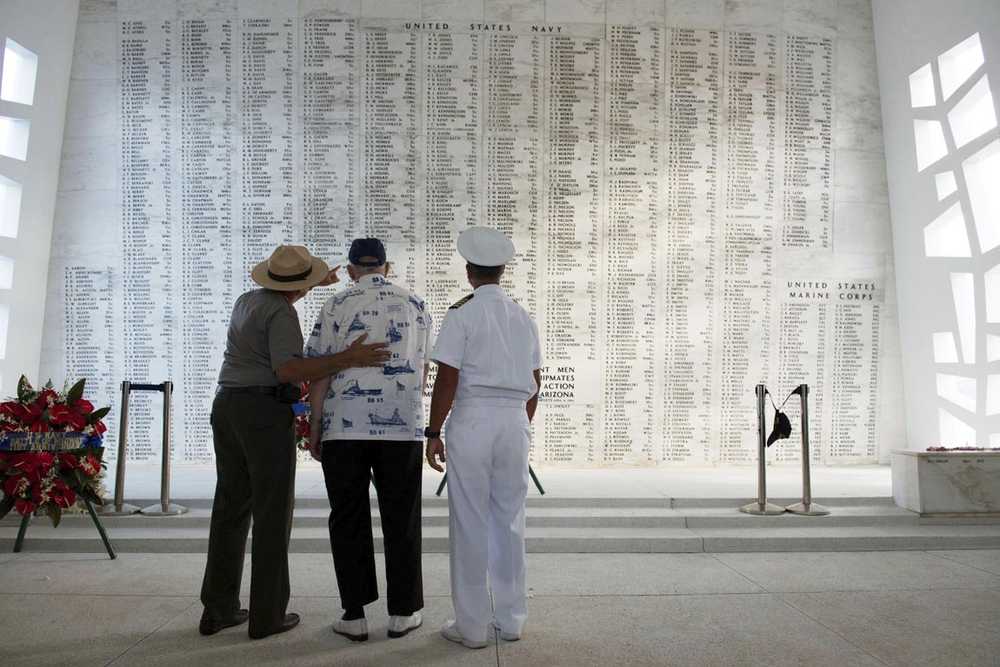 In this June 6, 2013 photo provided by the USS Arizona Memorial Foundation, Lauren Bruner, one of five remaining survivors of the USS Arizona from the Dec. 7, 1941, Japanese attack of Pearl Harbor, is joined by Capt. Jeffry W. James, right, then the commander of Joint Base Pearl Harbor-Hickam, and Daniel Martinez, chief historian for the National Park Service, as they look at the Arizona Memorial's Shrine Wall with names of every man aboard the ship when it was attacked. More than 2,300 servicemen died in the Japanese attack that plunged the United States into World War II. Nearly half of those killed were on the Arizona, most still entombed in the wreckage. (Mark Comon/USS Arizona Memorial Foundation via AP)