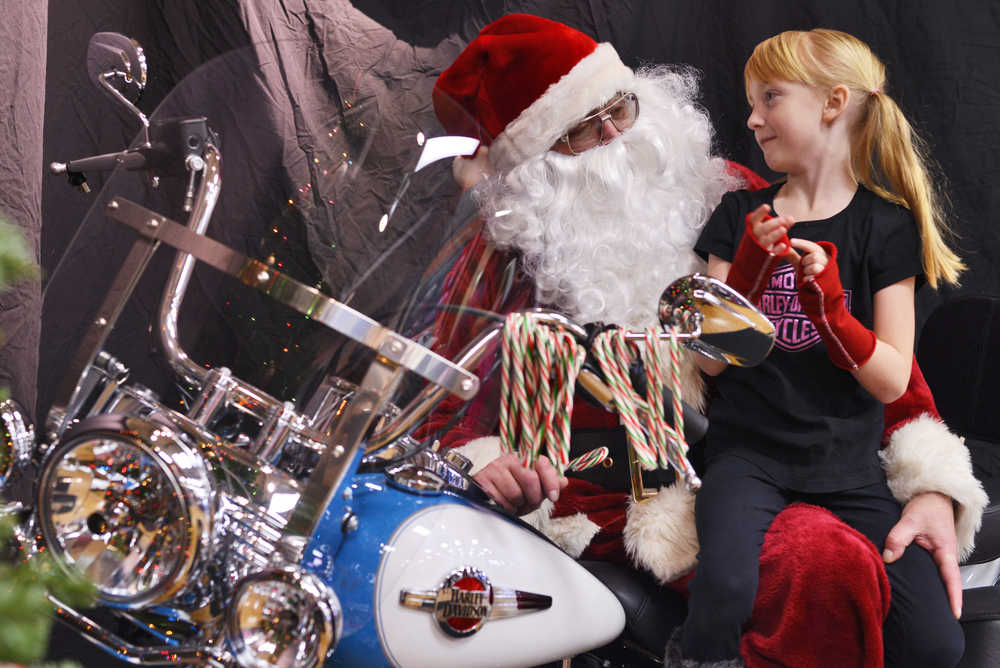 Photo by Ben Boettger Kelly Bookey, as Santa Claus, replenishes his stock of candy canes between visitors Saturday, Dec. 10, 2016 at the Kenai Peninsula Harley-Davidson store in Soldotna, Alaska. Bookey estimated that he has been appearing as Santa at the store for about 10 years, sitting on a motorcycle to distribute candy canes and pose for free photos. The Harley store is also hosting a Toys-for-Tots toy drive this year.