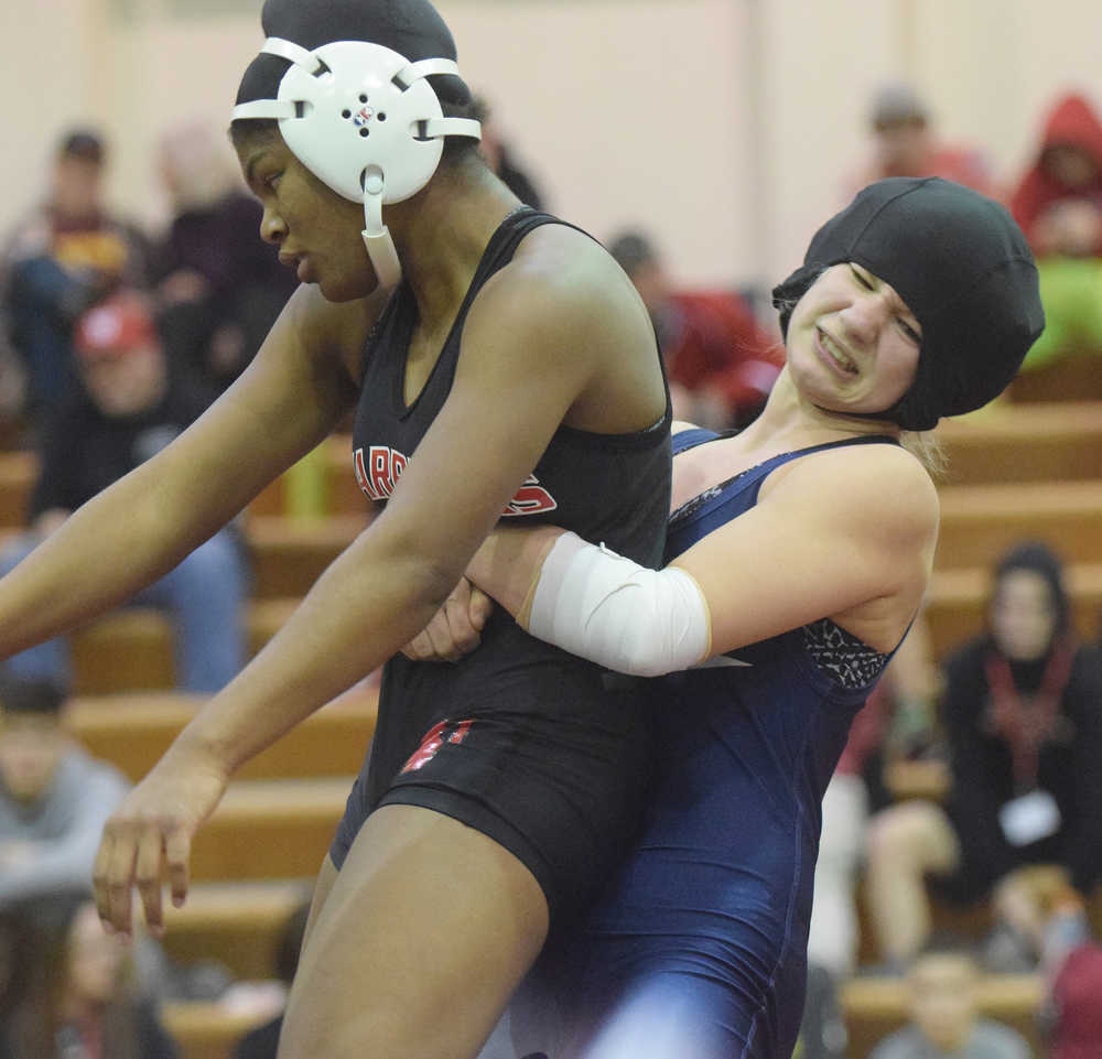 Photo by Joey Klecka/Peninsula Clarion Soldotna's Amanda Wylie grabs Teeana Nicholai of Wasilla in Saturday's 145-pound girls championship at the Northern Lights Conference tournament at Kenai Central HIgh School.