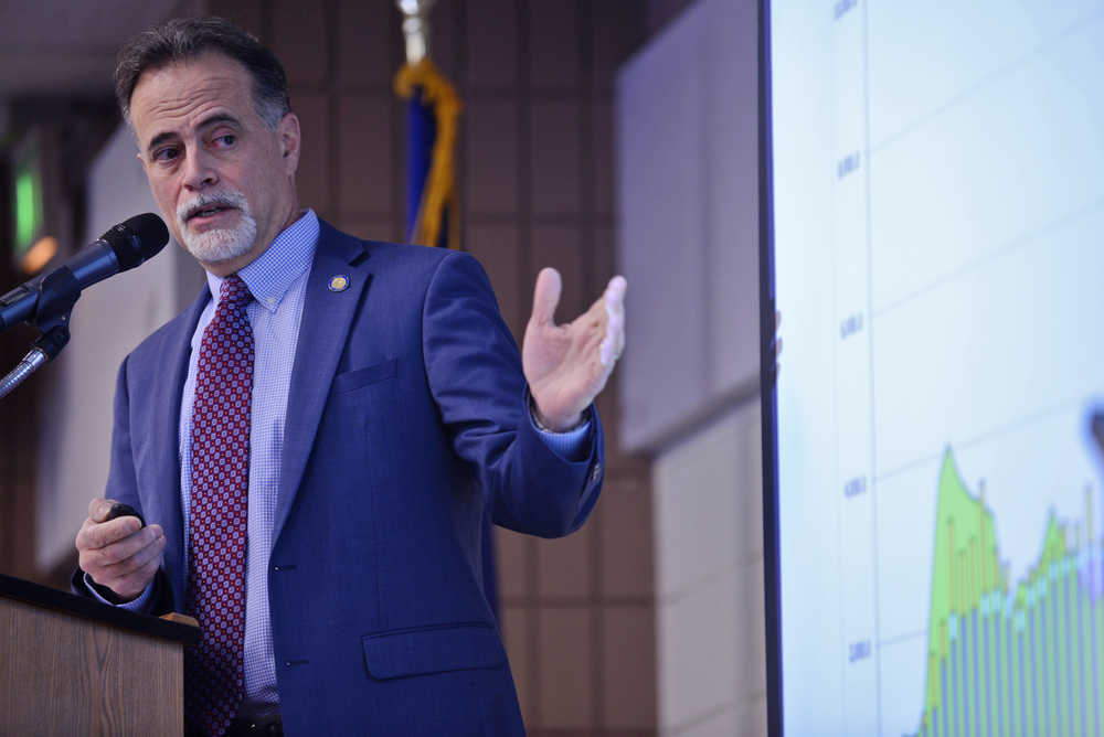 Ben Boettger/Peninsula Clarion Senator Peter Micciche (R-Soldotna) gestures at a graph of state economic data while presenting to members of the Kenai and Soldotna Chambers of Commerce on Tuesday, Dec. 13 at the Soldotna Regional Sports Complex.