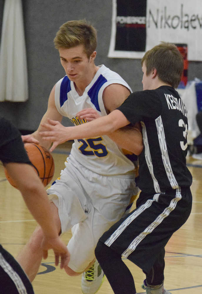 Photo by Joey Klecka/Peninsula Clarion Cook Inlet Academy senior Noah Leaf drives to the basket against Kodiak ESSS guard Ben Grossl, Thursday night at CIA.