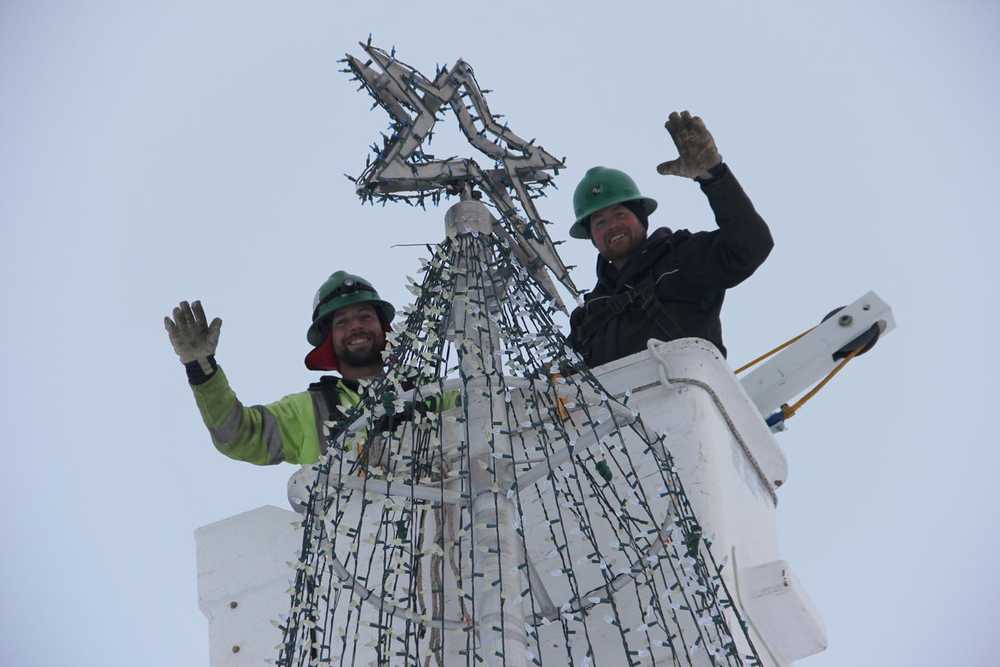 Jeremy Mann and Scott Morrison place the star atop the Soldotna Tree.