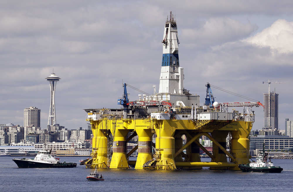FILE - In this May 14, 2015, file photo, the oil drilling rig Polar Pioneer is towed toward a dock in Elliott Bay in Seattle. The rig was the first of two drilling rigs Royal Dutch Shell was outfitting for Arctic oil exploration. President Barack Obama is expected to order wide swaths of the Atlantic and Arctic oceans placed permanently off-limits for oil drilling, in an 11th-hour push for environmental protection before he leaves office.  (AP Photo/Elaine Thompson, File)