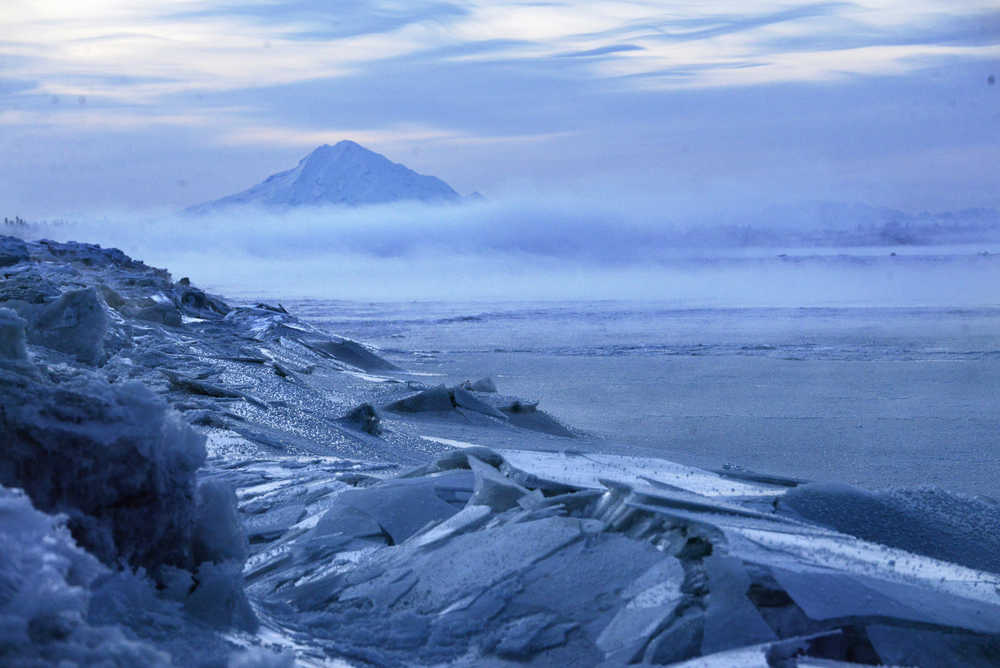 Photo by Ben Boettger/Peninsula Clarion  Broken plates of ice lay on the banks of the Kenai River as mist obscures the view of Mt. Redoubt on Thursday, Dec. 22 in Kenai.