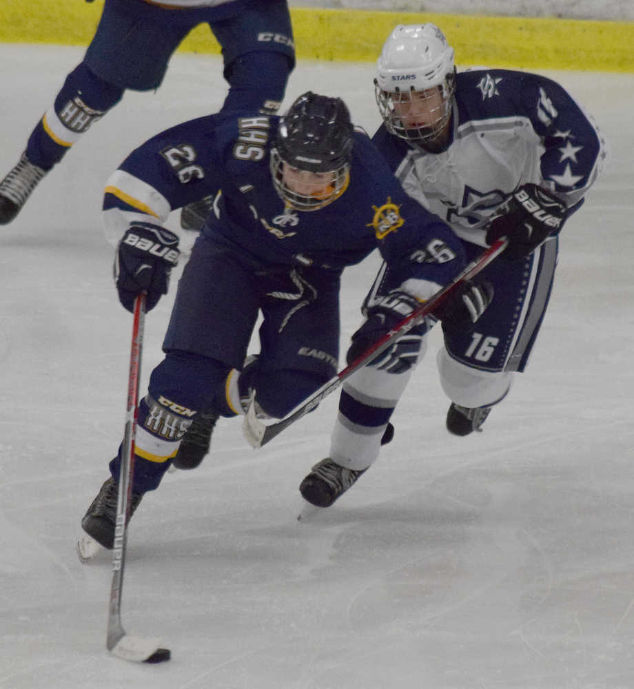 Photo by Joey Klecka/Peninsula Clarion Homer's Ethan Pitzman vies for control of the puck against Soldotna's Wyatt Medcoff (16), Thursday evening at the Soldotna Regional Sports Complex.