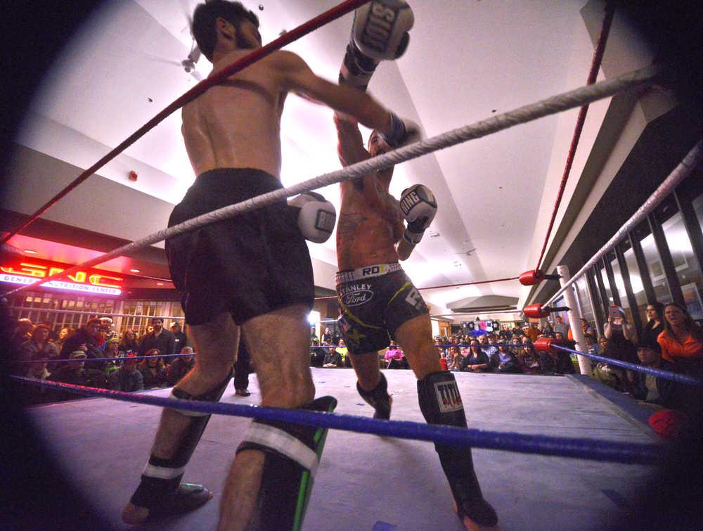 Ben Boettger/Peninsula Clarion Kickboxers Jay Harris and Codyne Williams (left) fight in the main event of the Fight Before Christmas martial arts event on Thursday, Dec. 22 at Soldotna's Peninsula Center Mall. Harris beat Williams by decision of the judges.