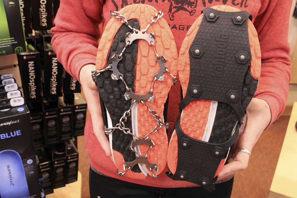 In this Tuesday, Nov. 29, 2016, photo Emma Bohman, a sales associate at Skinny Raven sporting goods, shows two kinds of exterior cleats attached to running shoes in Anchorage, Alaska. Exterior cleats are one of many ways Anchorage residents cope with up ice on streets up to seven months per year. (AP Photo/Dan Joling)