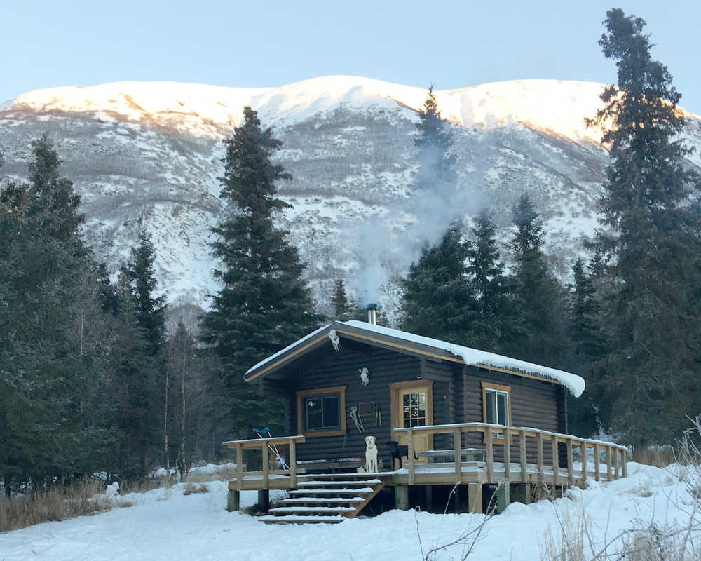 Lucy and Leo wait for Clarion editor Will Morrow on the front porch of Barber Cabin on Lower Russian Lake in Chugach National Forest on Sunday, Jan. 1, 2017. (Photo by Will Morrow/Peninsula Clarion)