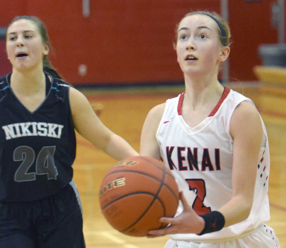 Photo by Jeff Helminiak/Peninsula Clarion Kenai Central's Jaycie Calvert gets by Nikiski's Kelsey Clark and the rest of the defense for a layup Thursday at Kenai Central.