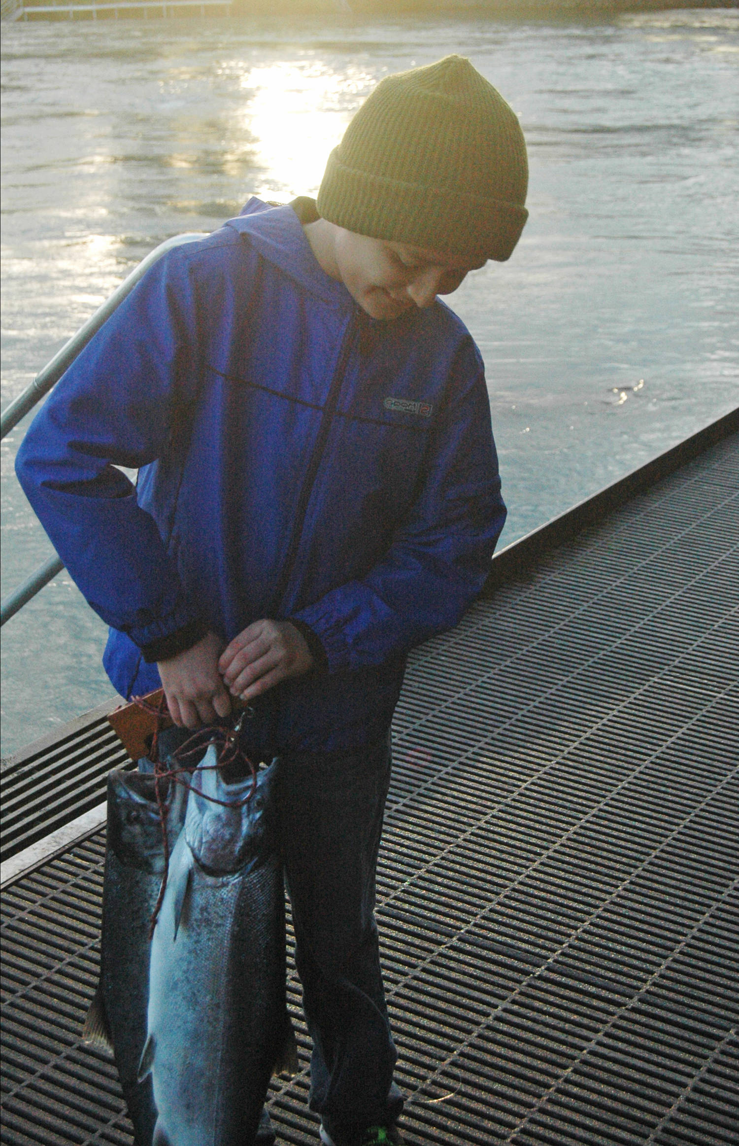 Joseph Barba of California holds up the two silver salmon he caught on the Kenai River from the boardwalk near the Soldotna Visitors Center on Wednesday, Aug. 8, 2018 in Soldotna, Alaska. (Photo by Elizabeth Earl/Peninsula Clarion)