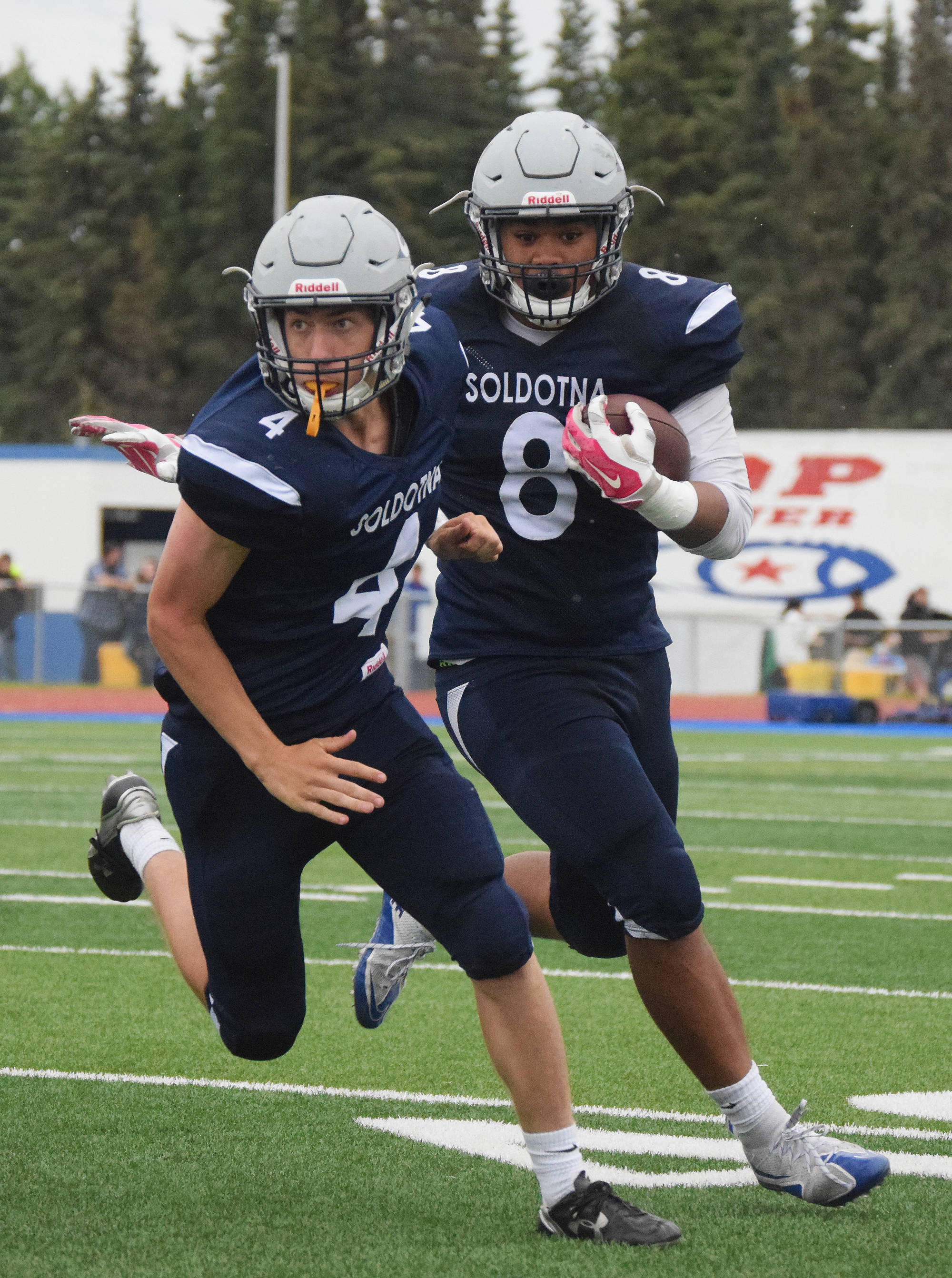 Soldotna junior Aaron Faletoi follows the block by teammate Jersey Truesdell Friday against West Anchorage at Justin Maile Field in Soldotna. (Photo by Joey Klecka/Peninsula Clarion)