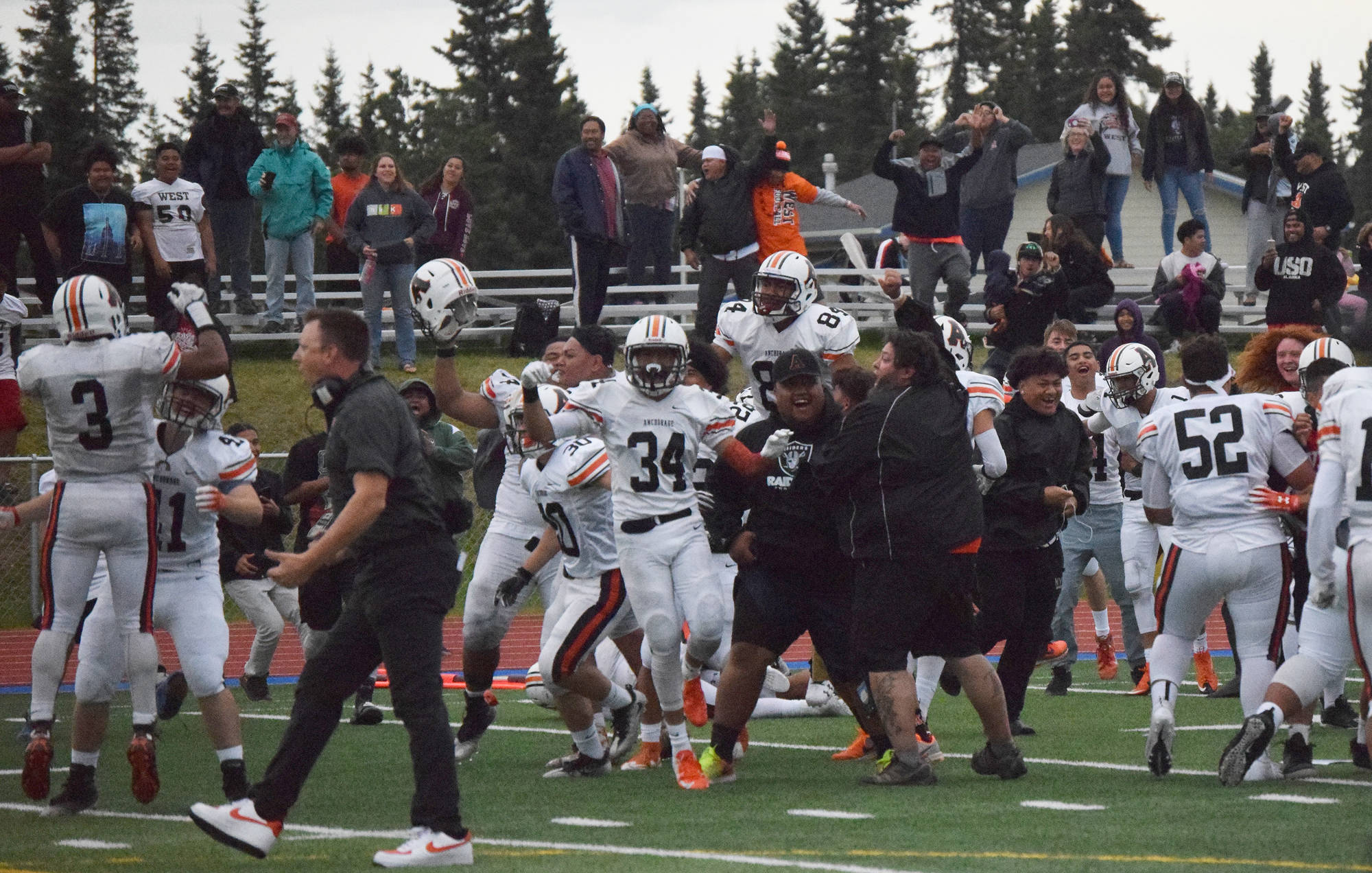 West football players and fans celebrate on field after defeating Soldotna 18-13 Friday at Justin Maile Field in Soldotna. (Photo by Joey Klecka/Peninsula Clarion)