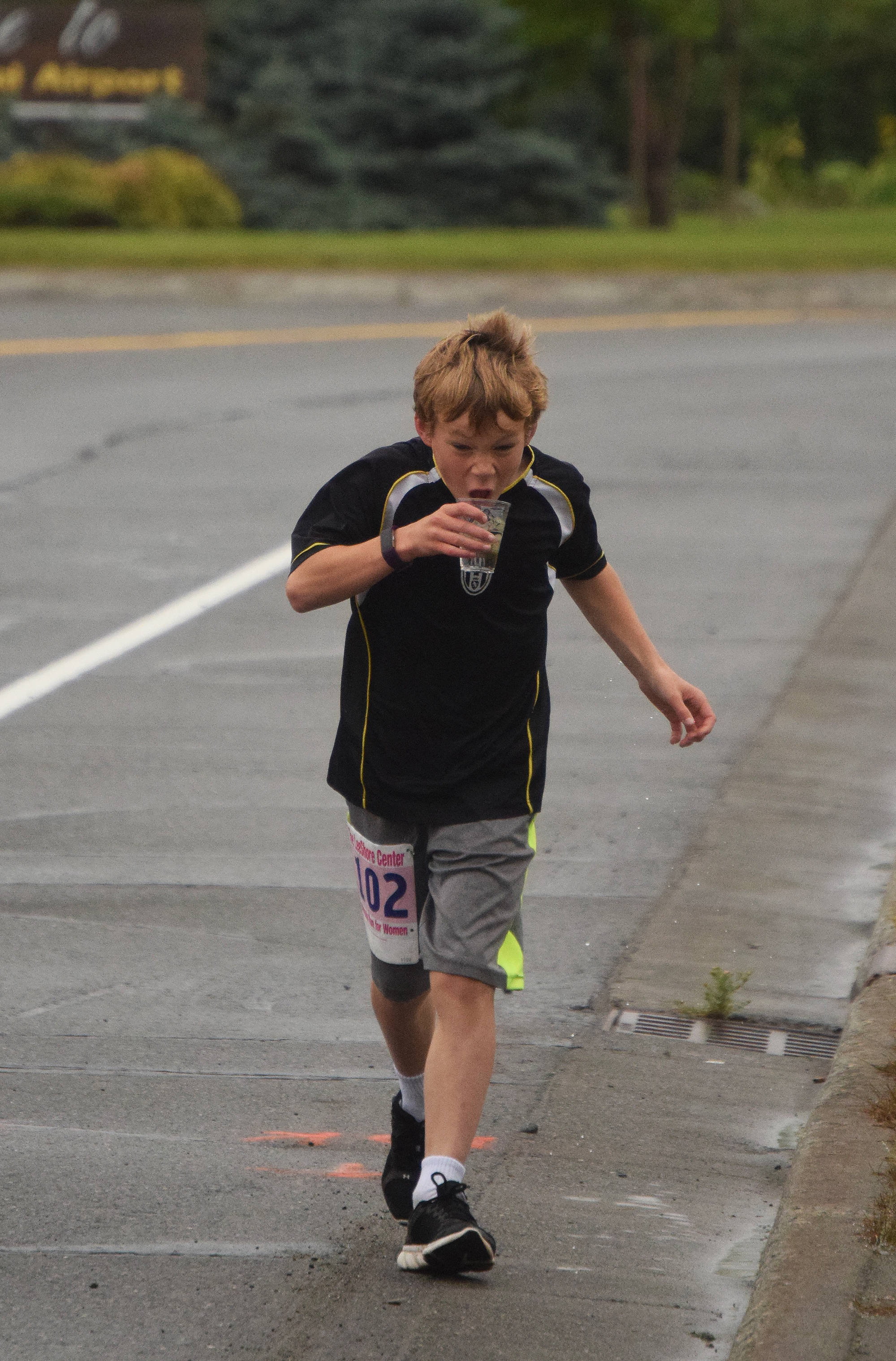 Samuel Anders takes a drink of water early in Saturday morning’s 10K race in the 31st annual LeeShore Center Run for Women in Kenai. (Photo by Joey Klecka/Peninsula Clarion)