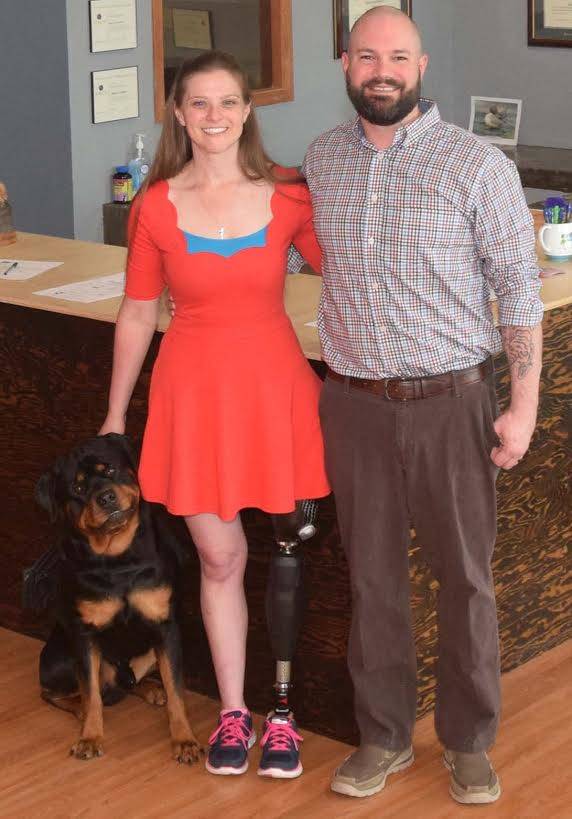 Dr. Jennifer Reed and Dr. Adam Hawkins with their rottweiler, Tank, who is training to be Reed’s service dog. (Photo courtesy of Puffin Chiropractic)