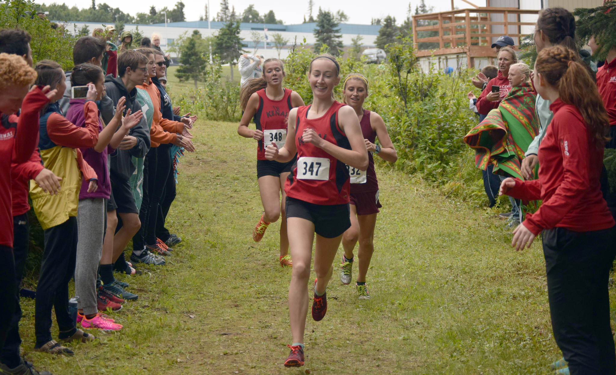 Kenai Central senior Jaycie Calvert paces the lead pack past spectators in the girls junior-senior race at the Nikiski Class Races on Monday, Aug. 13, 2018, at Nikiski High School. Calvert went on to win the race. (Photo by Jeff Helminiak/Peninsula Clarion)