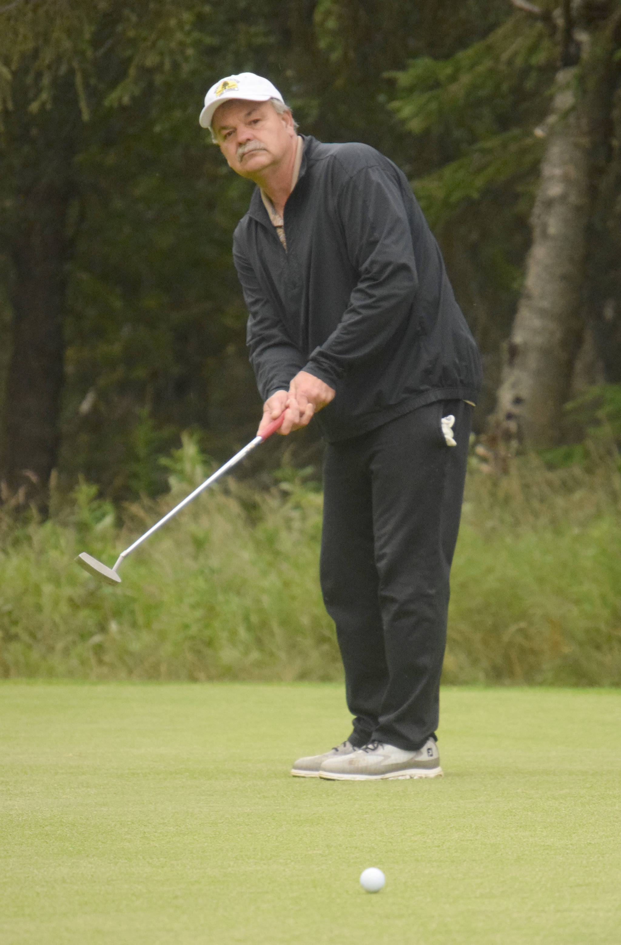 Birch Ridge’s Jeff Hetrick tracks his putt on the third green at Kenai Golf Course during the Peninsula Cup on Wednesday, Aug. 15, 2018. Hetrick dunked a hole-in-one on No. 10, his first shot of the tournament. (Photo by Jeff Helminiak/Peninsula Clarion)