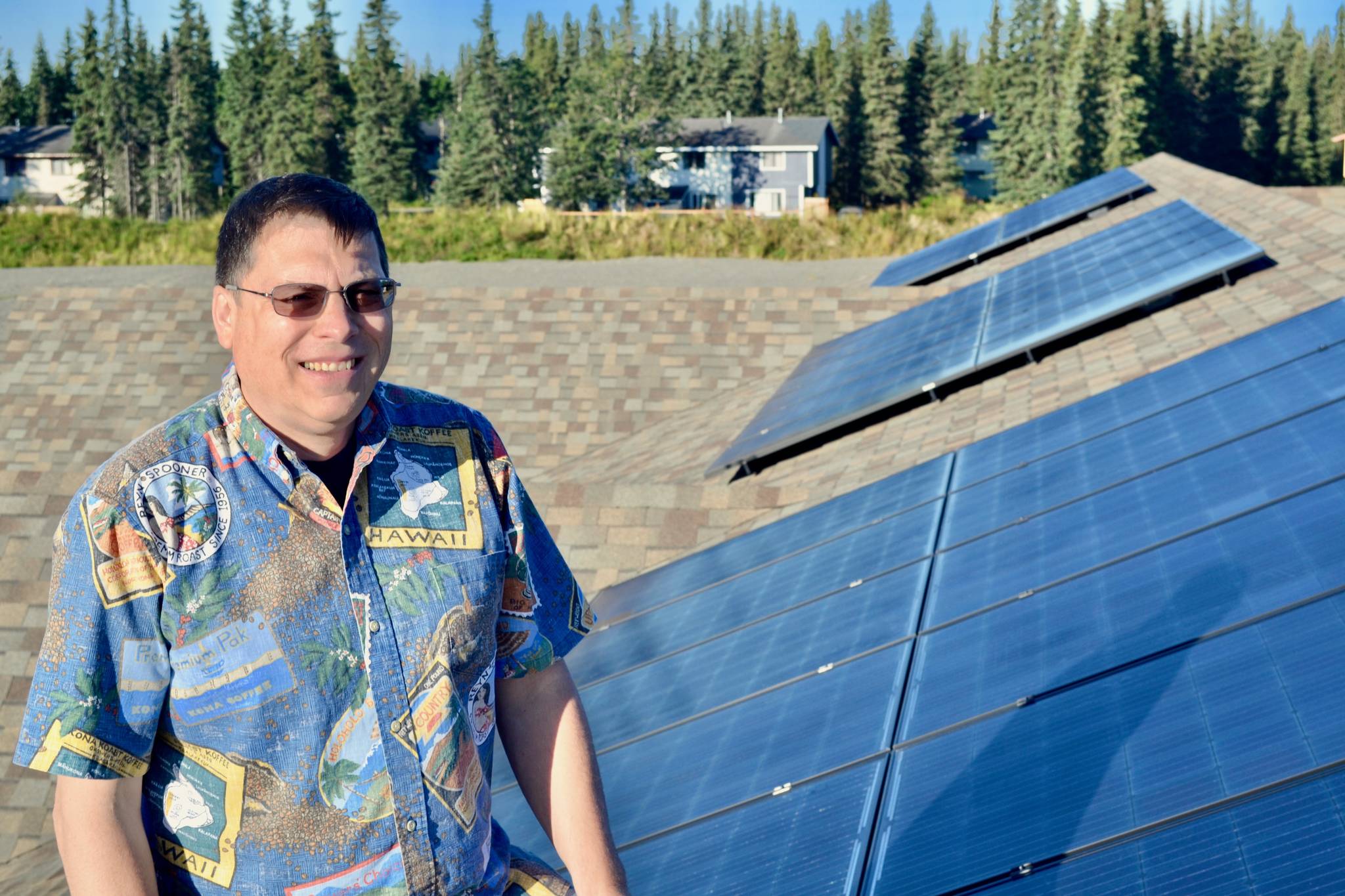 Dale Bagley on top of the roof of his business, Redoubt Realty, where he installed 48 solar panels earlier this summer on Friday, Aug. 17, 2018 near Soldotna, Alaska. (Photo by Victoria Petersen/Peninsula Clarion)