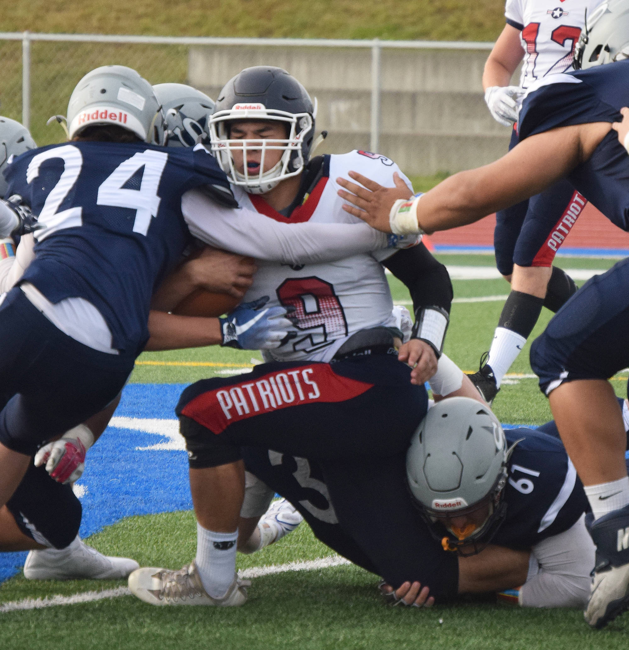 North Pole senior Bradley Antesberger (9) gets wrapped up by Soldotna defensive backs Cam Johnson (24) and Levi Benner (61) Friday at Soldotna’s Justin Maile Field. (Photo by Joey Klecka/Peninsula Clarion)