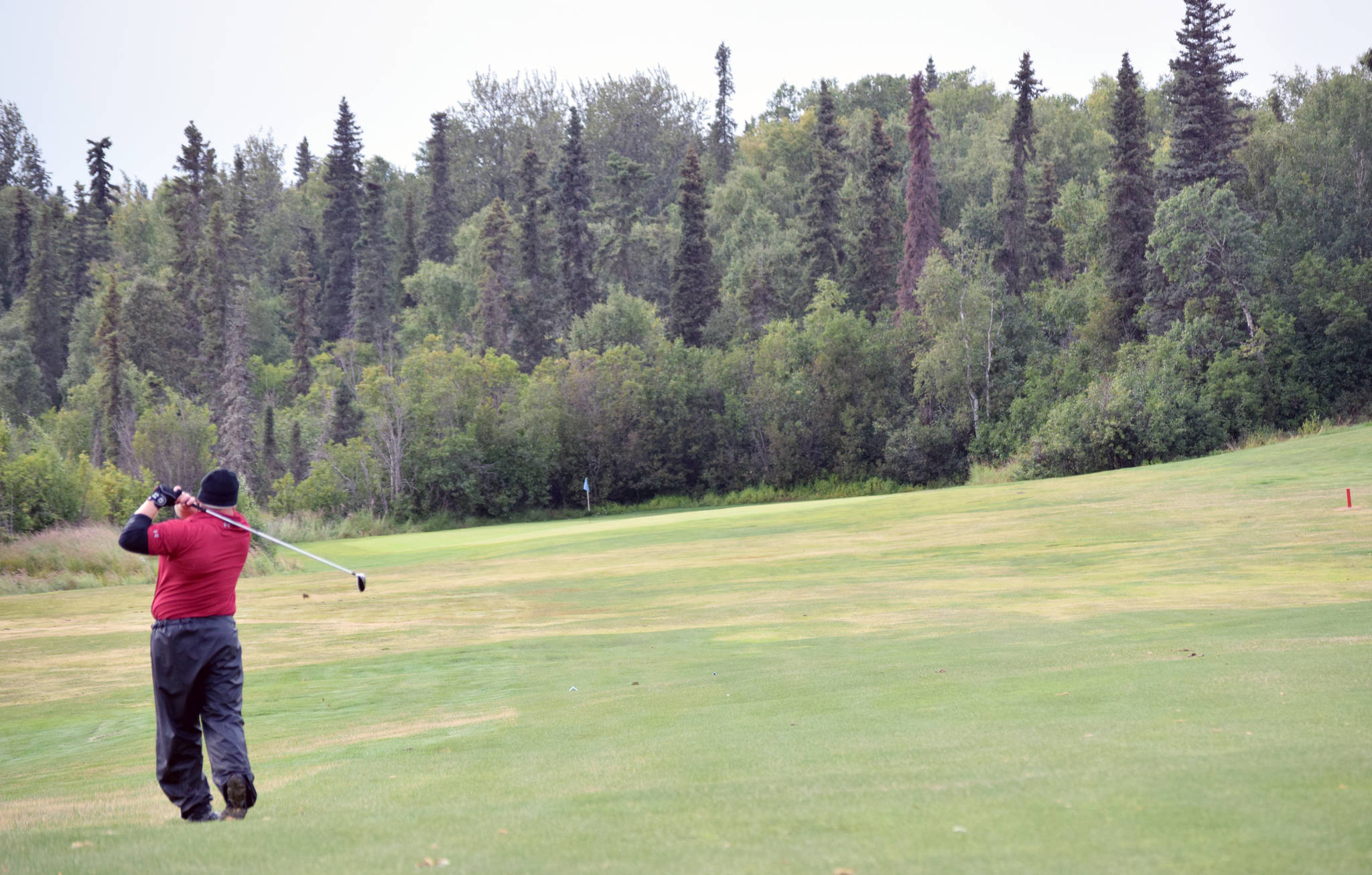 Jason Woodruff hits his approach on the 16th fairway at Kenai Golf Course on Sunday, Aug. 19, 2018, during the Peninsula Cup. (Photo by Jeff Helminiak/Peninsula Clarion)