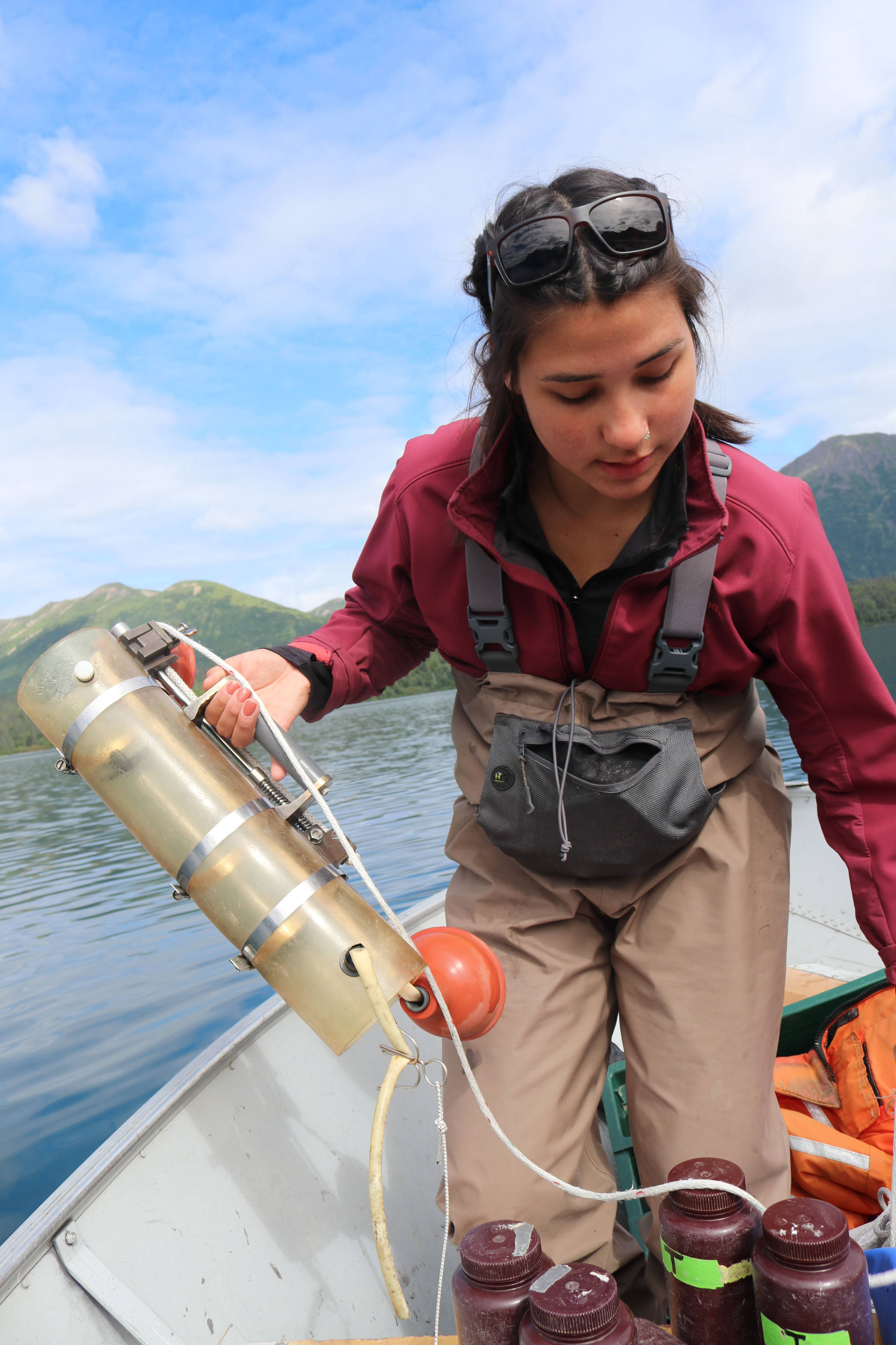 Danielle Lowrey, a Bristol Bay Native Association intern from Bethel, prepares a Van Dorn, which takes water samples that will later be filtered for algae concentration, on Kulik Lake in the Bristol Bay watershed on August 9, 2018. Mary Catharine Martin | SalmonState