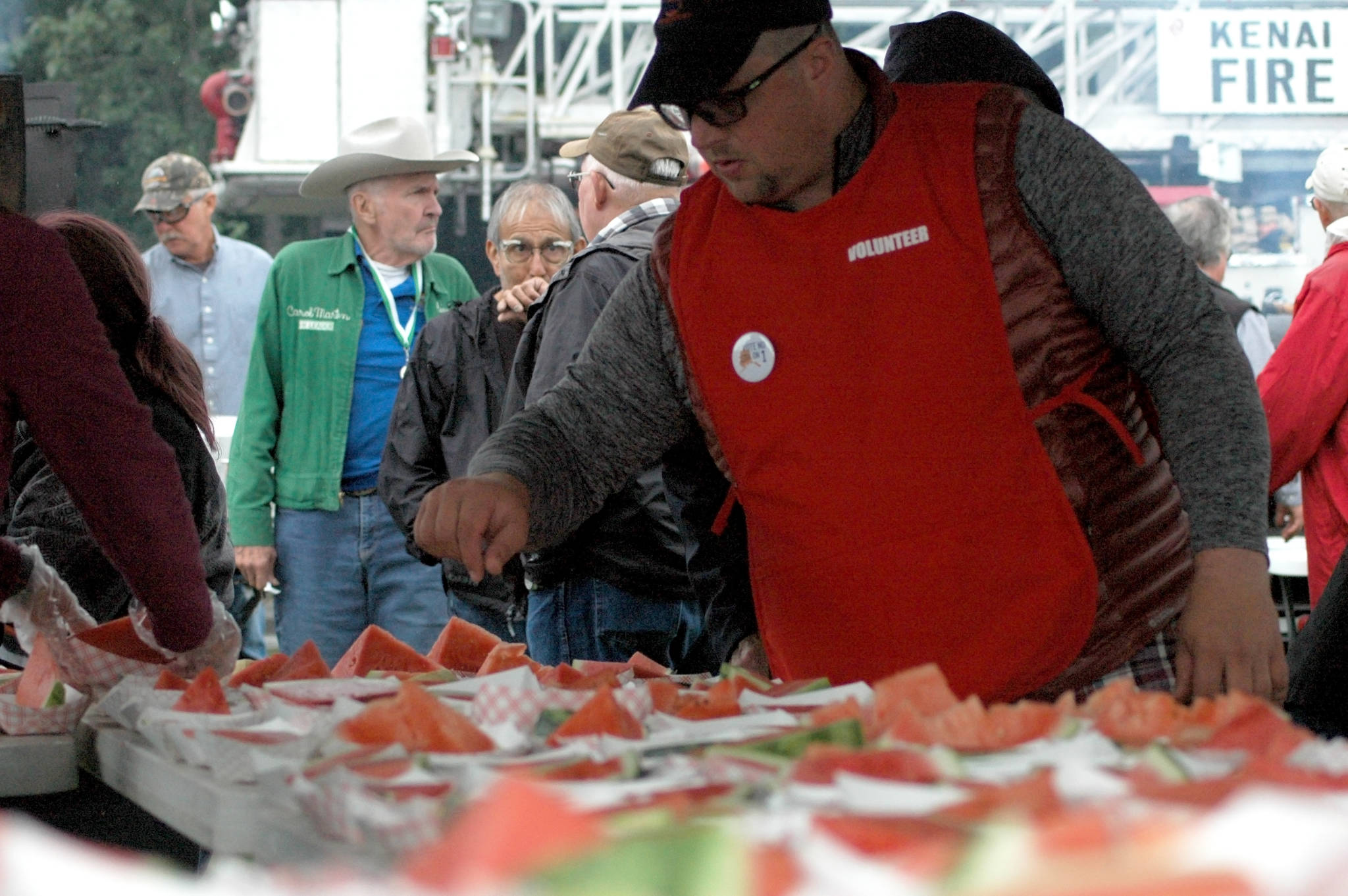 A volunteer inspects the supply of watermelon available at Industry Appreciation Day on Saturday, Aug. 25, 2018 in Kenai, Alaska. (Photo by Elizabeth Earl/Peninsula Clarion)
