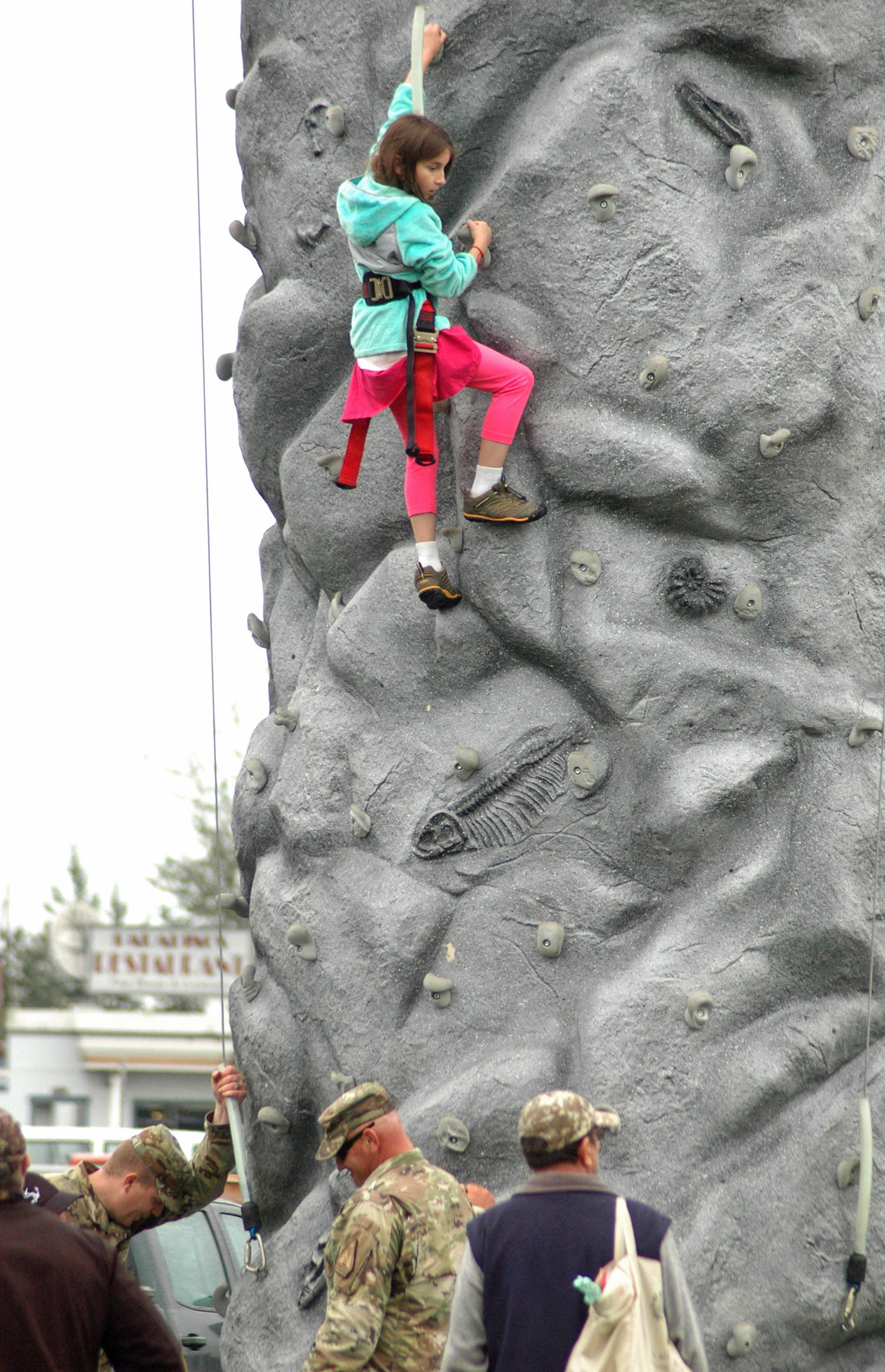 A young climber makes her way up a rock wall monitored by Alaska Army National Guard members at Industry Appreciation Day on Saturday, Aug. 25, 2018 in Kenai, Alaska. (Photo by Elizabeth Earl/Peninsula Clarion)