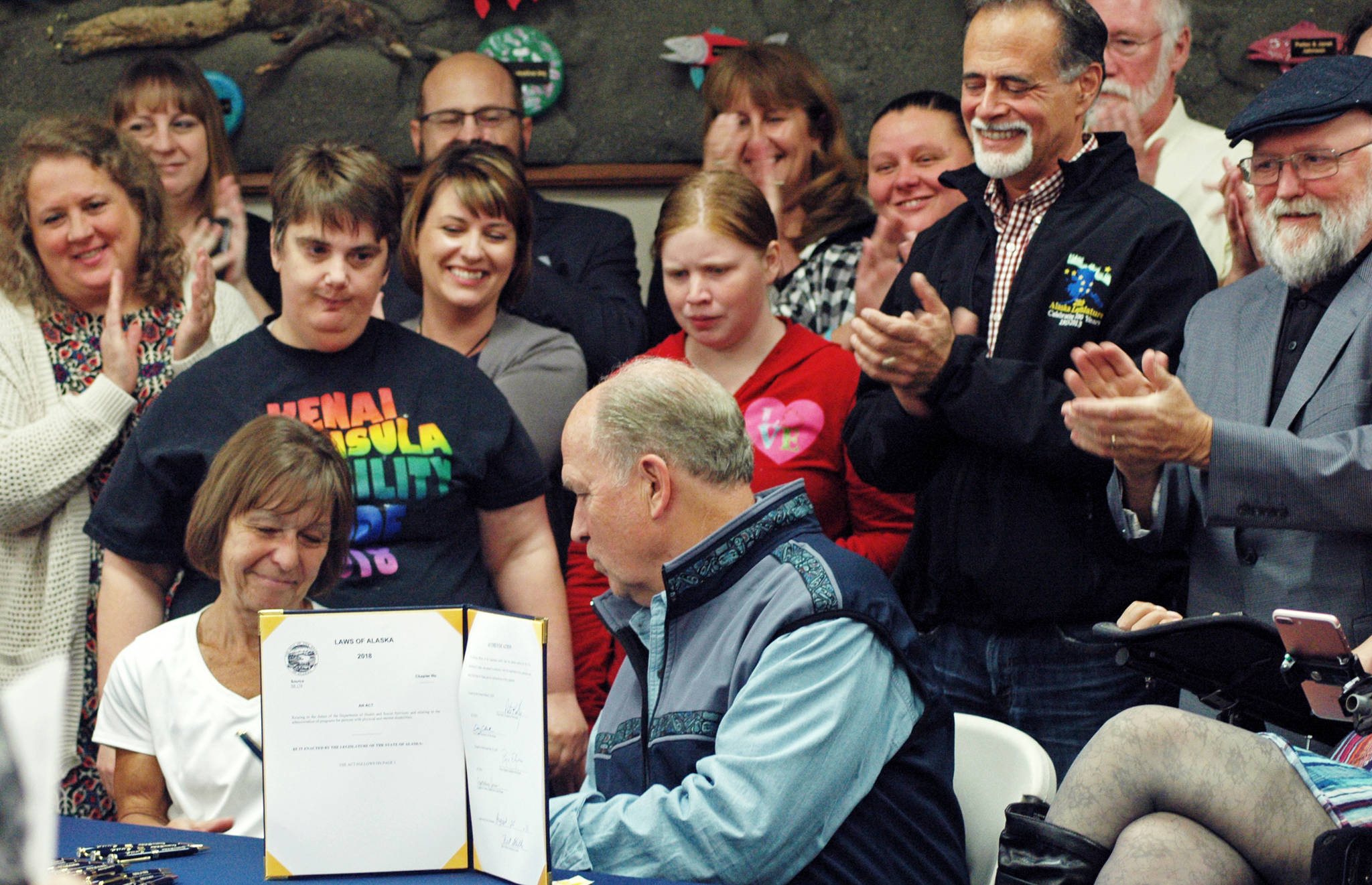 Gov. Bill Walker (center) speaks with Jill Skidmore-Erickson, a member of Access Alaska’s Board of Directors, during a signing ceremony for Senate Bill 174 on Saturday, Aug. 25, 2018 in Soldotna, Alaska. (Photo by Elizabeth Earl/Peninsula Clarion)