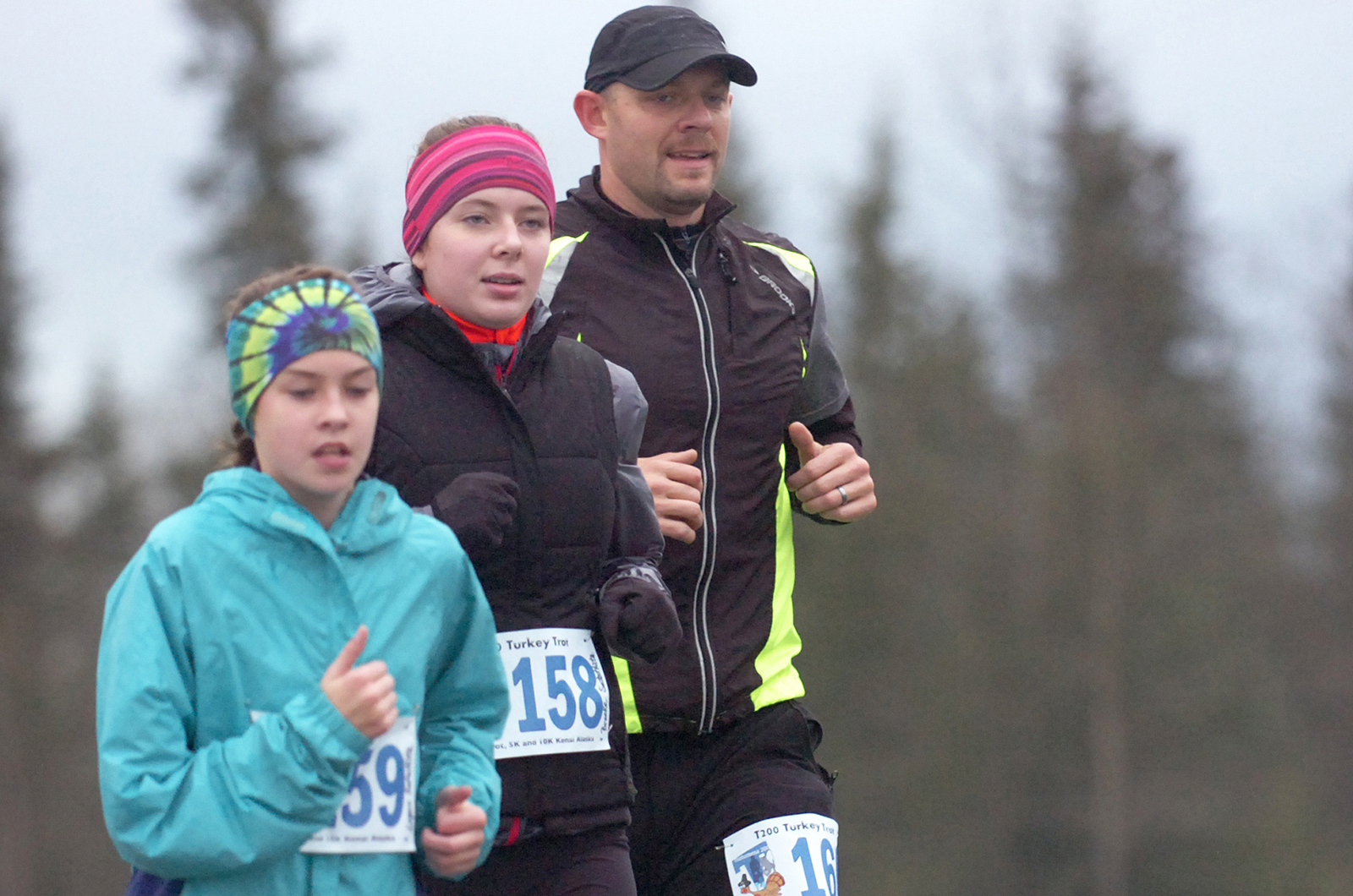 Logan Satathite (left) runs with Brooke Satathite and Sam Satathite in the Tsalteshi Trails Turkey Trot 10-kilometer race on Friday, Nov. 27 near the Soldtona Sports Center.