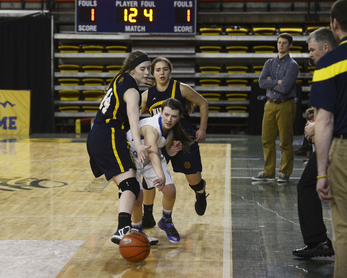 Homer juniors Madison Akers (front) and Aurora Waclawski trap an ACS player against the sidelines in Friday's matchup against the Lions at the Sullivan Arena. Homer lost 34-23.