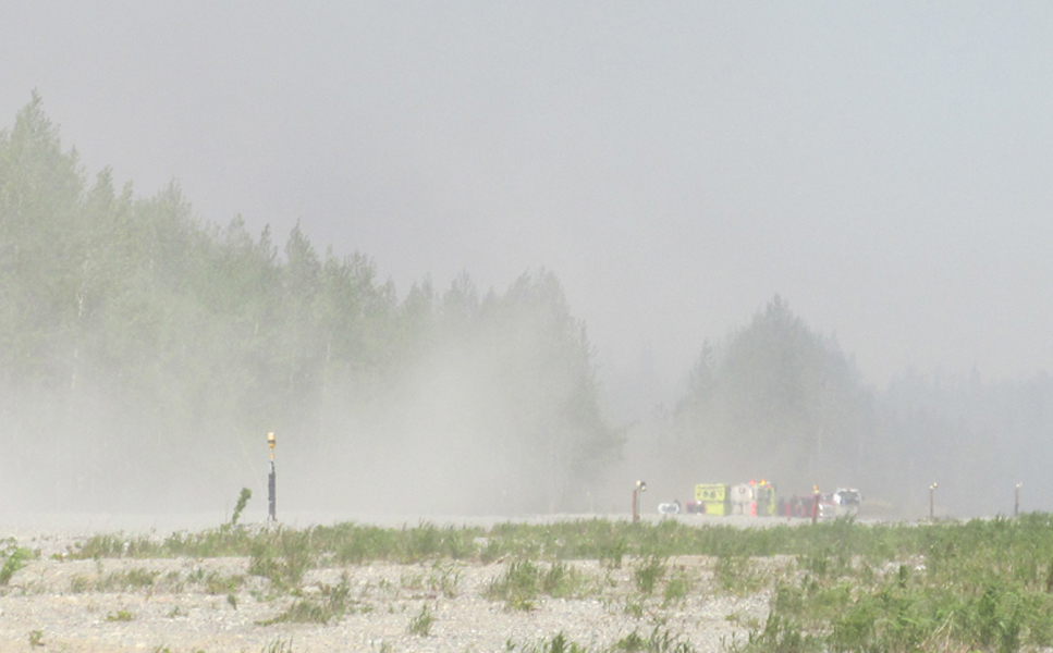 Emergency crews stage at the end of the runway in Tyonek Monday afternoon. The blaze grew to 80 acres by Monday evening.