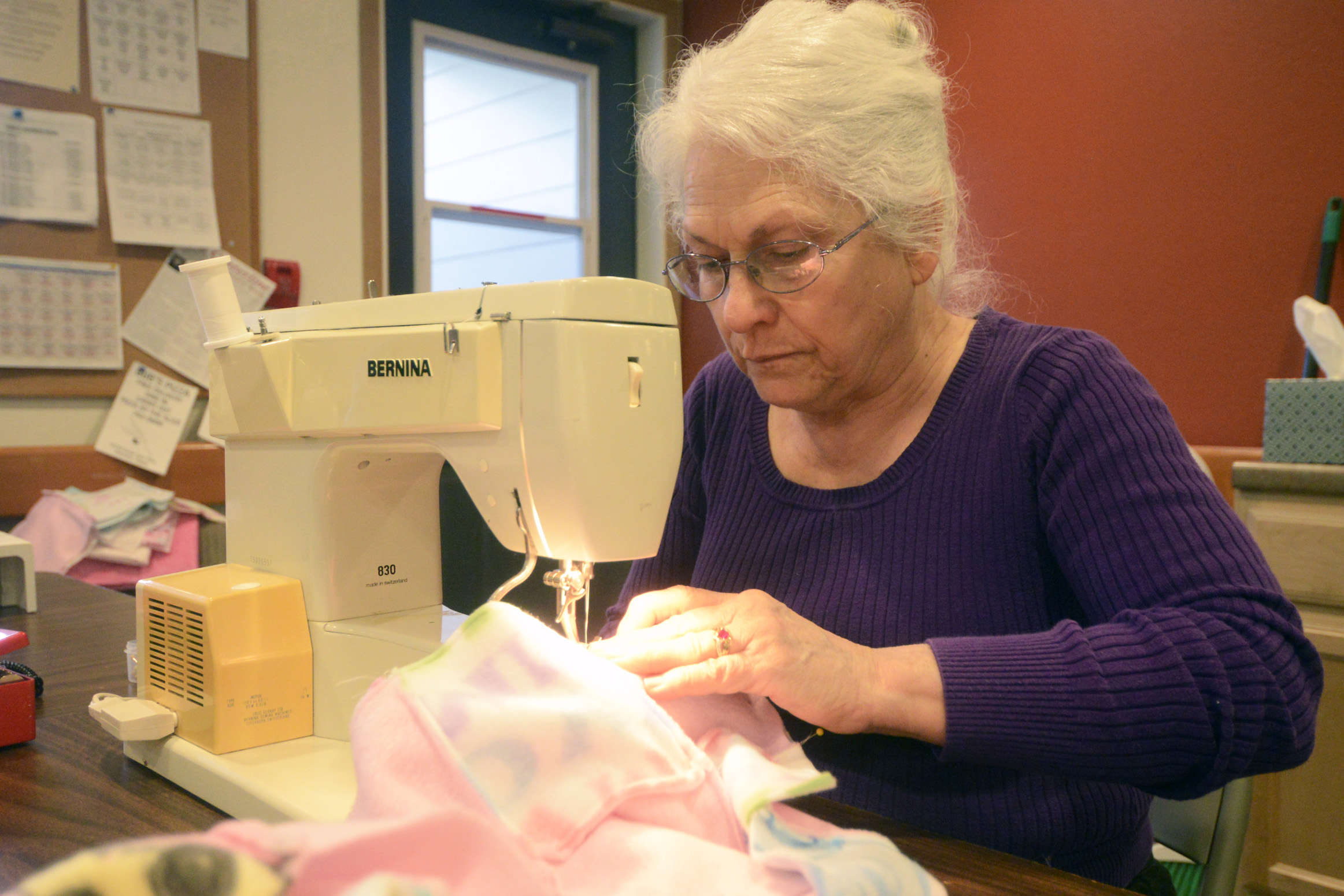 Colleen Maricle works on an unfinished quilt during a craft session on Tuesday, March 1, 2016 at Northwood Apartments in Soldotna, Alaska. A group of local crafters make and donate quilts to Alaska State Troopers and other organizations for them to give out to children in need.
