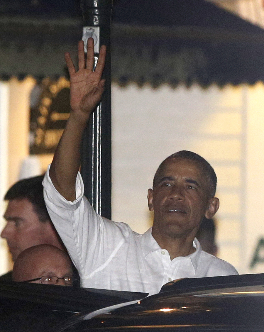 President Barack Obama waves to people on the street as he departs a restaurant late Wednesday, Aug. 12, 2015, in Edgartown, Mass., on the island of Martha's Vineyard. The president, first lady Michelle Obama and daughter Sasha are vacationing on the island.