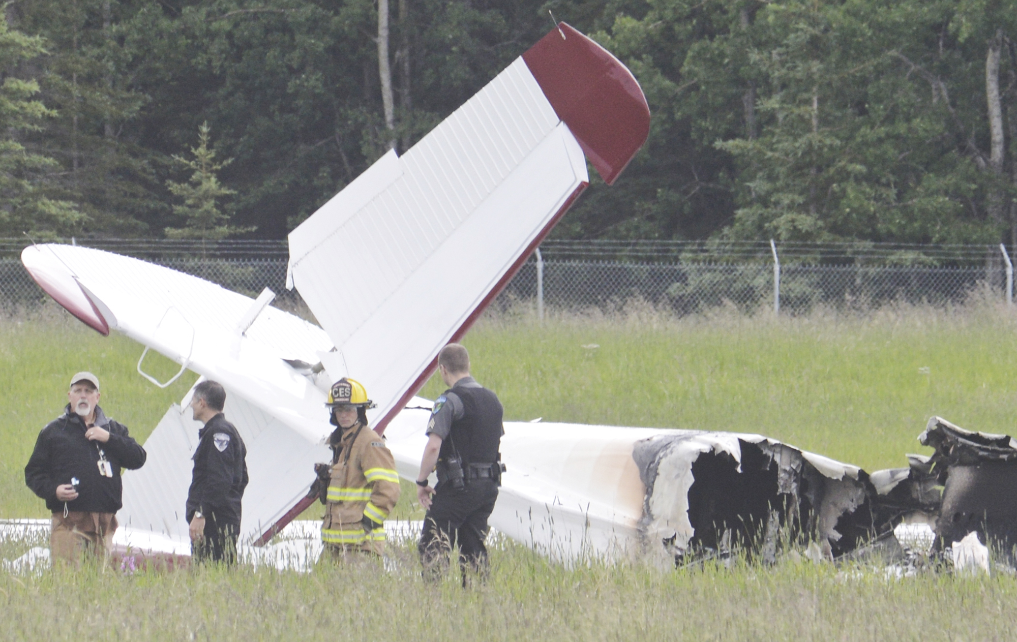 In this July 7, 2013 file photo investigators look at the remains of a fixed-wing aircraft that was engulfed in flames  at the Soldotna Airport in Soldotna, Alaska. No survivors were located. Ten people died in the the crash.