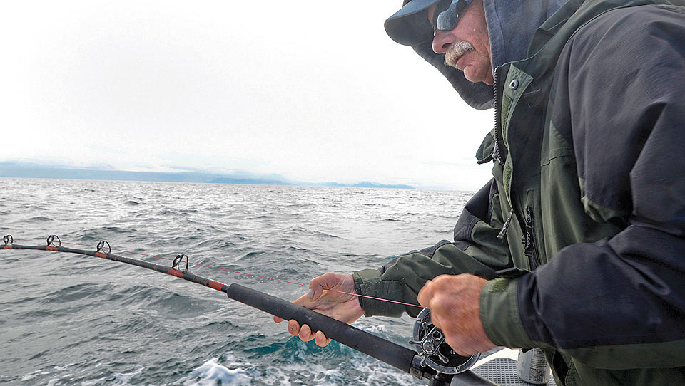A Nevada man lets his line out while fishing for halibut just west of the tractor-powered Anchor Point boat launch.